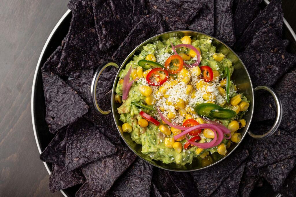 Fresh, chef-prepared guacamole with blue corn chips from the Planet Hollywood NYC menu.