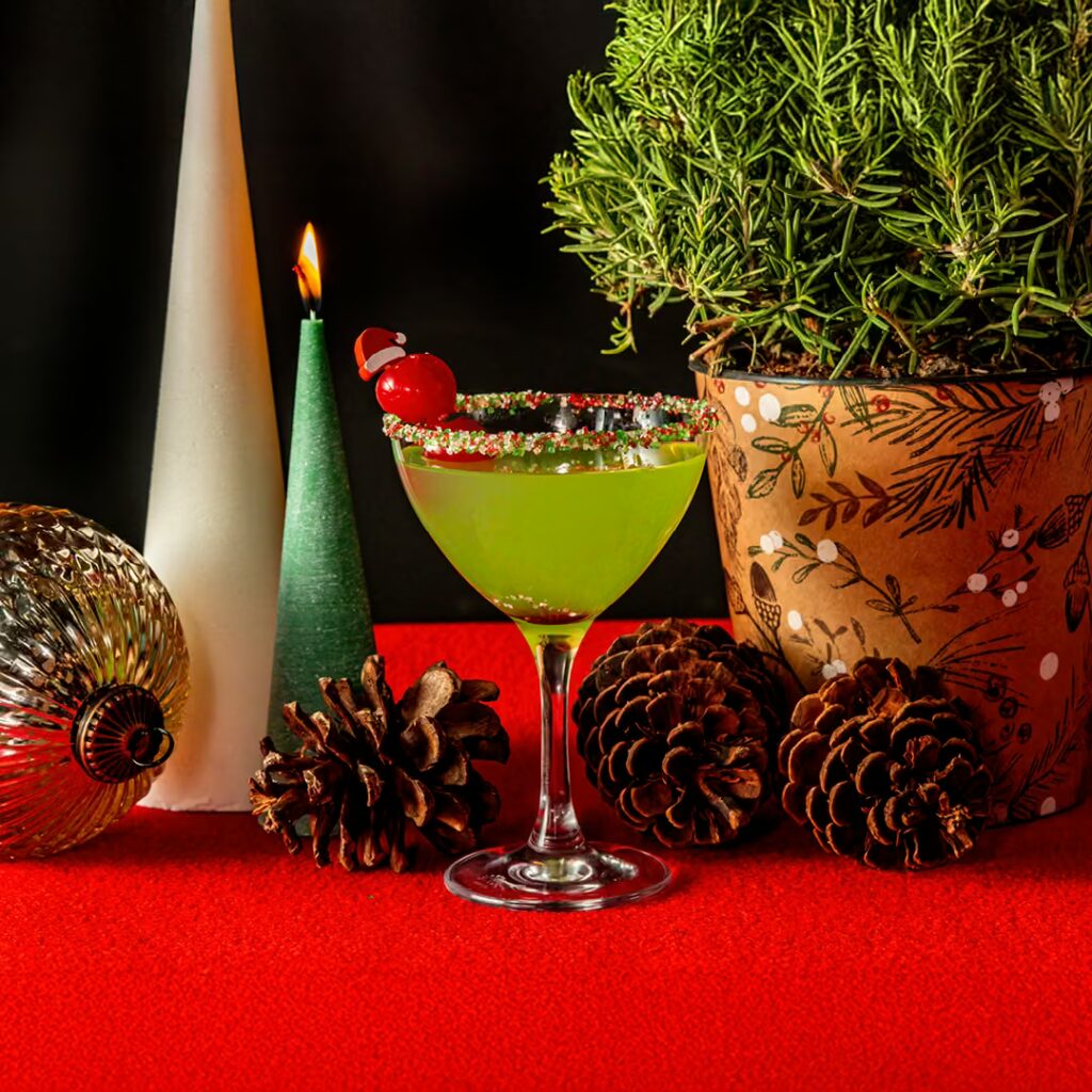 Green holiday cocktail with cherry Santa garnish at Planet Hollywood NYC