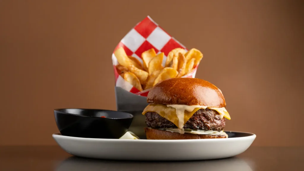 Cheeseburger with melted cheese, fries and dipping sauce at Planet Hollywood NYC.